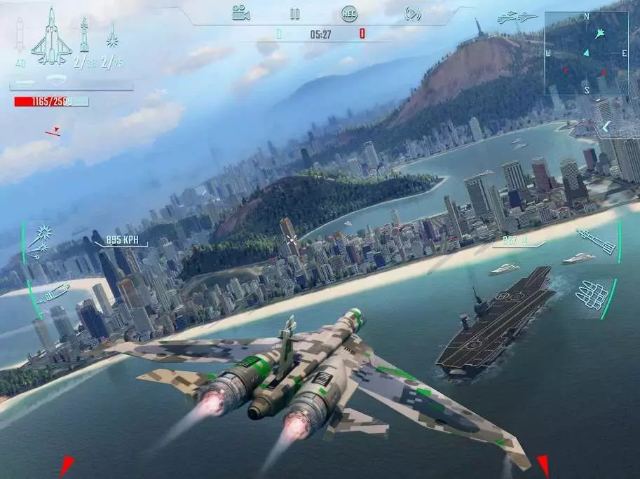 Ảnh 5 của Tải game Sky Gamblers – Infinite Jets Mod APK 1.2.1 (Vô Hạn Tiền) Một chiếc máy bay phản lực ngụy trang bay qua một thành phố ven biển và một tàu sân bay